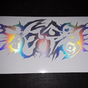 May include: A holographic sticker with a stylized design featuring a swirling pattern and sharp edges. The sticker is iridescent with shades of blue, green, yellow, and orange.