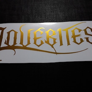 May include: Gold vinyl decal with the word "Lovebites" in a gothic font.