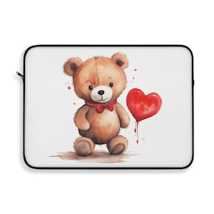 May include: A white laptop sleeve featuring a watercolor illustration of a brown teddy bear wearing a red bow tie and holding a red heart-shaped balloon. The design has a black zipper and trim.