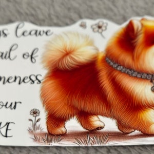 May include: A sticker featuring a Pomeranian dog with orange and cream fur, wearing a jeweled collar and a heart-shaped pendant. The sticker has the text "Always leave a trail of awesomeness in your WAKE."