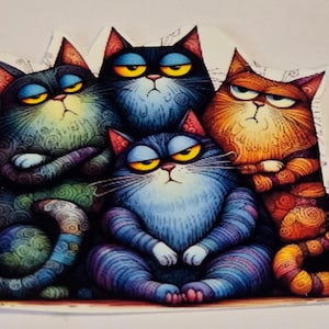 May include: A colorful illustration of four grumpy cats. The cats are in various shades of blue, orange, and green, with yellow eyes and crossed arms. The artwork has a whimsical, cartoonish style.