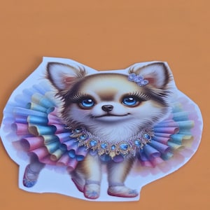 May include: A charming Chihuahua illustration wearing a colorful tutu, jeweled collar, and a bow. The dog has big blue eyes and is wearing ballet slippers. The artwork is on a white background with a light orange backdrop.
