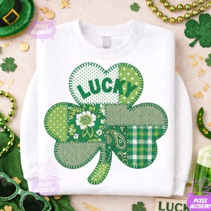 Può includere: Felpa bianca con un grande trifoglio verde. Il trifoglio è composto da vari motivi verdi e dalla scritta "LUCKY" in verde. Il design è centrato sulla parte anteriore della felpa, perfetto per San Patrizio.