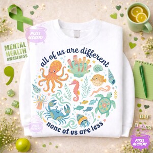 May include: White crewneck sweatshirt with a colorful sea life design. The graphic includes an octopus, seahorse, crab, and other sea creatures. Text reads "all of us are different, none of us are less."