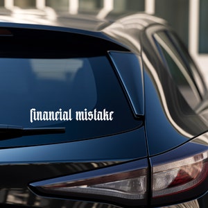 Puede incluir: Un coche negro con una pegatina de vinilo blanco en la ventana trasera que dice "financial mistake".