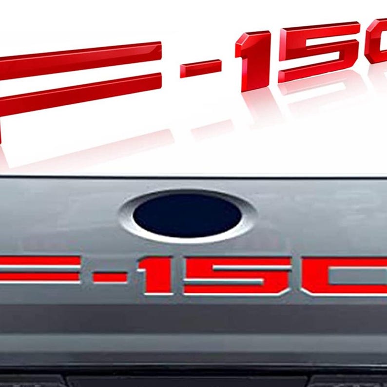 Puede incluir: Emblema rojo F-150, con las letras y n&uacute;meros en estilo 3D. El emblema se muestra en dos vistas diferentes, una con las letras y n&uacute;meros separados y la otra con el emblema adjunto a un veh&iacute;culo.