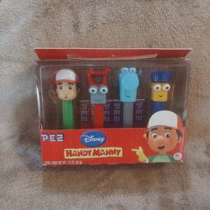 May include: A set of four Handy Manny character Pez dispensers in a red, white, and blue box. The dispensers feature Handy Manny, Rusty,  Pat, and  Dusty. The box has the Disney logo and the text "Handy Manny".