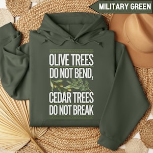 Pode incluir: Um moletom com capuz verde militar com o texto "Olive Trees Do Not Bend, Cedar Trees Do Not Break" em letras brancas. O texto é cercado por um padrão verde e branco.
