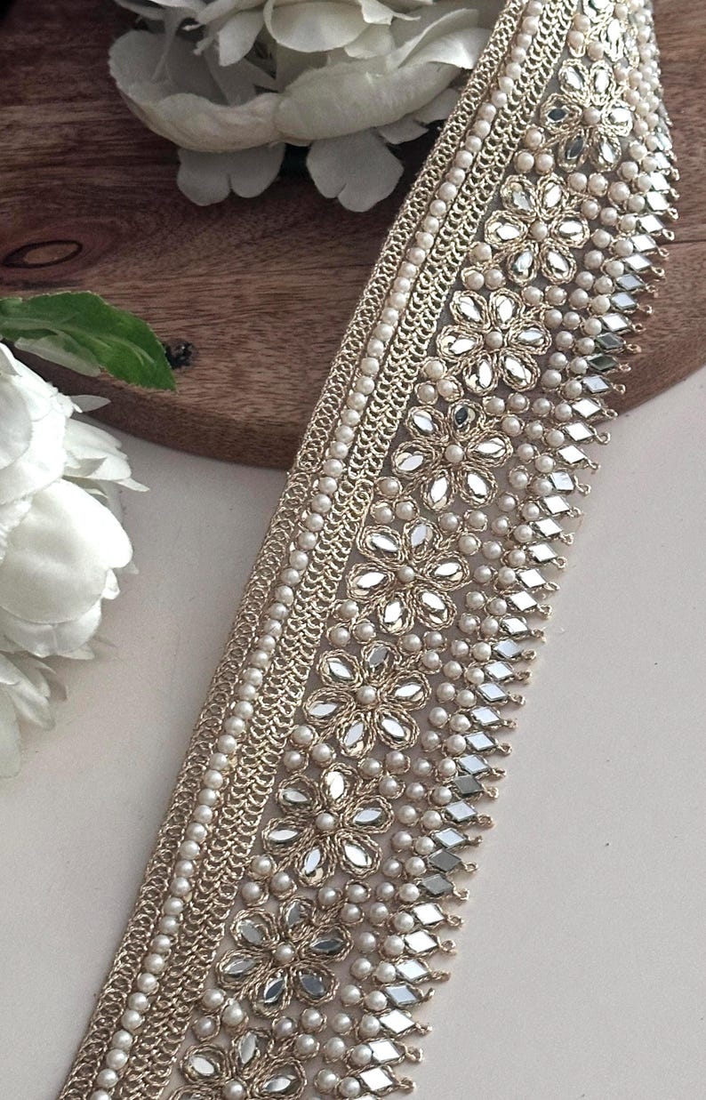 Bundle and strip of gold floral lace with mirror and pearl embellishments, styled for use in bridal, festive, or costume design.