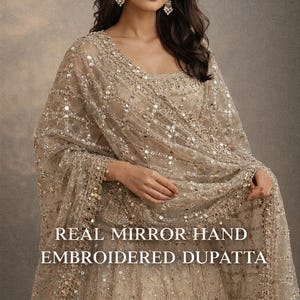 Real mirror work jal dupatta folded on white surface showing hand embroidered lattice pattern on soft net fabric