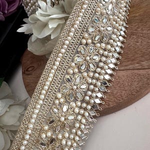 Bundle and strip of gold floral lace with mirror and pearl embellishments, styled for use in bridal, festive, or costume design.