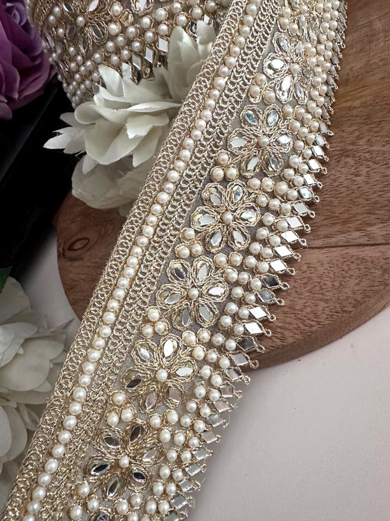 Bundle and strip of gold floral lace with mirror and pearl embellishments, styled for use in bridal, festive, or costume design.