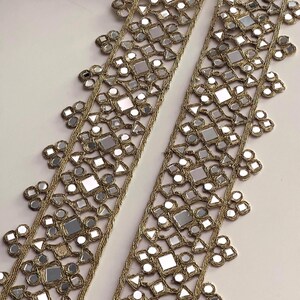 Reflective mirror belt lace trim laid out on a white surface, ideal for making boho-chic cinturon belts and wedding crafts.