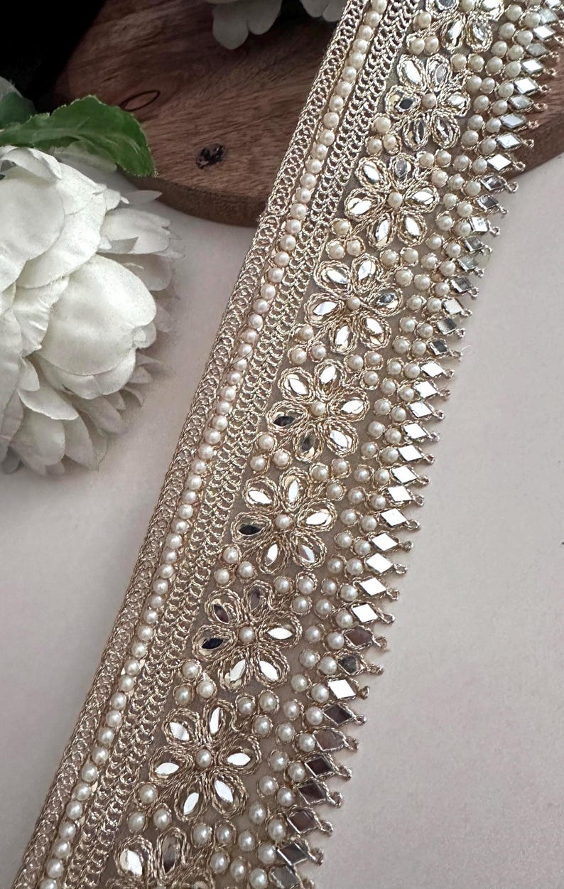 Bundle and strip of gold floral lace with mirror and pearl embellishments, styled for use in bridal, festive, or costume design.