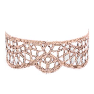 Op de afbeelding: Een delicate choker ketting met een gegolfde rand, met een ingewikkeld ontwerp van gespiegelde tegels in een lichtbruine kleur.