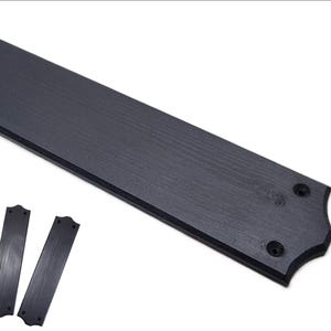 以下が含まれることがあります： 黒い木製のドアプレートのセット。長方形のプレート1枚と、小さなプレート4枚が含まれています。プレートは木目調で、取り付け用の穴が開いています。大きなプレートには装飾的な縁があります。