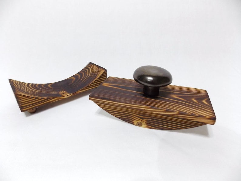 K&ouml;nnte beinhalten: Zwei Tintenf&auml;sser aus Holz mit einem schwarzen Keramikdeckel. Die Tintenf&auml;sser sind aus dunklem Holz mit einer Holzmaserung.