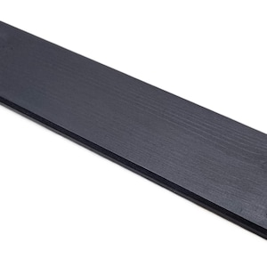 Peut inclure: Une tasse en céramique blanche avec une anse noire et le texte "But First, Coffee" en noir, en gras. La tasse est posée sur une surface blanche.