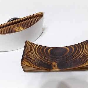 K&ouml;nnte beinhalten: Zwei gebogene Serviertabletts aus Holz. Ein Tablett ist aus Naturholz mit einer wei&szlig;en Oberfl&auml;che. Das andere Tablett ist dunkelbraun mit einer Holzmaserung.