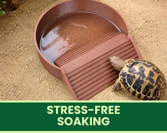 Könnte beinhalten: Eine braune, kreisförmige Wasserschale mit einer strukturierten Rampe, die in das Becken führt, und einer kleinen Schildkröte neben der Rampe. Der Text STRESS-FREE SOAKING steht auf einem grünen Banner am unteren Bildrand.