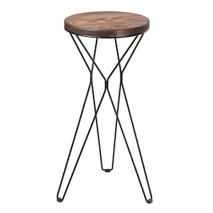 Op de afbeelding: Een kleine ronde houten tafel met een zwart metalen frame. De tafel heeft een eenvoudig ontwerp met drie poten die elkaar kruisen.