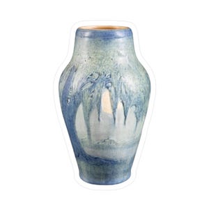 May include: A ceramic vase with a blue and white glaze. The vase has a wide body that tapers towards the top and bottom. The blue glaze drips down the sides, creating a textured effect. The rim is a darker blue.