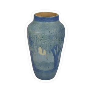 May include: A blue ceramic vase with a landscape design. The vase has a light blue exterior with darker blue accents and a brown interior. The design features a tree and a landscape scene.