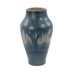 May include: A blue ceramic vase with a tree design. The vase has a wide base that tapers to a narrower neck and a flared rim. The tree design is painted in shades of blue and white, with a light brown rim.