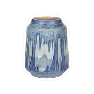 May include: A ceramic vase with a cylindrical form and a light blue and dark blue glaze. The glaze has a dripped effect, creating a textured appearance. The interior of the vase is a light tan colour.