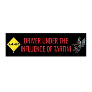 Puede incluir: Adhesivo rectangular negro con texto rojo: "DRIVER UNDER THE INFLUENCE OF TARTINI". Un letrero de advertencia amarillo está a la izquierda y un diablo tocando el violín a la derecha.