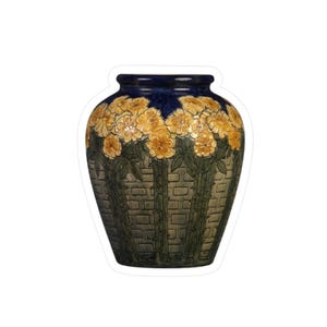 May include: A ceramic vase with a dark blue rim, featuring yellow flowers and green foliage. The vase has a textured, brick-like pattern in shades of green and brown. A decorative piece for the home.