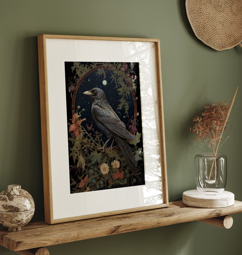 May include: Framed art print featuring a black crow perched on a branch in a lush, green forest setting. The crow is surrounded by flowers and leaves, and the background is a dark, moody sky. The print is framed in a simple, wooden frame.