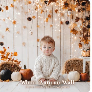May include: A young child in a white sweater sits in front of a white wooden wall backdrop. The scene is decorated with pumpkins, hay bales, and autumn leaves. Text at the bottom reads "White Autumn Wall" and "Digital Photography Backdrop."