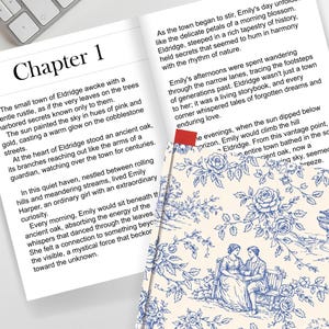 May include: Open book with text and a decorative bookmark. The page reads "Chapter 1" and describes a town. A patterned bookmark with a blue floral design and a couple sitting on a bench is visible.
