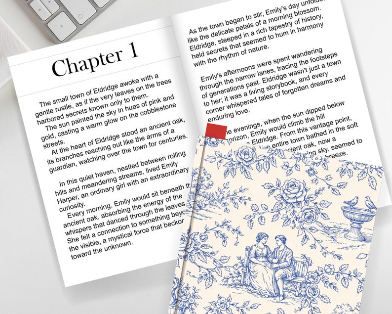 May include: Open book with text and a decorative bookmark. The page reads "Chapter 1" and describes a town. A patterned bookmark with a blue floral design and a couple sitting on a bench is visible.