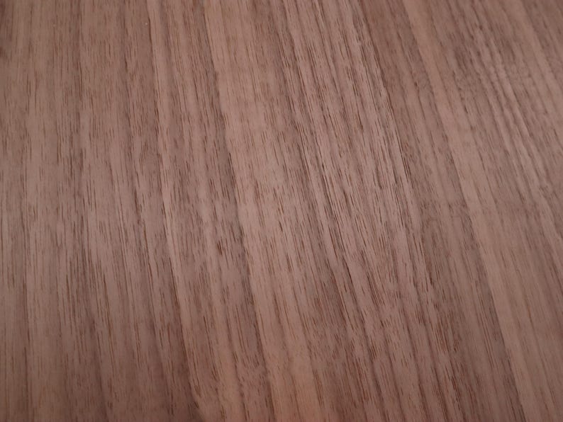 May include: Close-up of a wood grain surface with a reddish-brown color. The grain is straight and runs diagonally across the image.