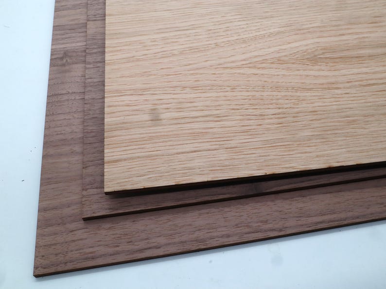 May include: Three pieces of wood, one light brown and two dark brown, stacked on top of each other.