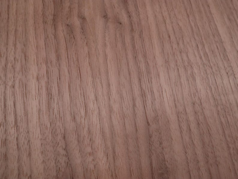 May include: A close-up of a smooth, light brown wood surface with a natural wood grain pattern.