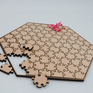 May include: A wooden jigsaw puzzle in the shape of a hexagon, with some pieces missing. The puzzle is made of light brown wood and has a natural finish. The pieces are all the same size and shape, and they fit together perfectly. The puzzle is a fun and challenging way to spend time with friends and family.
