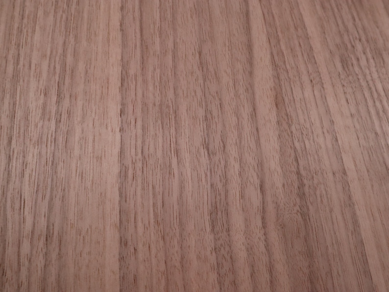 May include: Close-up of a light brown wood grain surface. The wood has a natural, smooth finish.