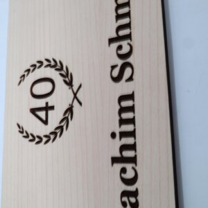 May include: A wooden plaque with the number 40 inside a laurel wreath and the text "achim Schm" below.