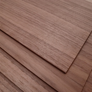 May include: Stacked sheets of light brown wood veneer. The wood grain is visible and has a natural, rustic look.
