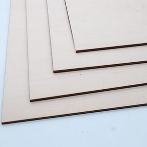 May include: Four pieces of unfinished wood veneer plywood, stacked on top of each other. The plywood is light brown in colour and has a smooth surface.