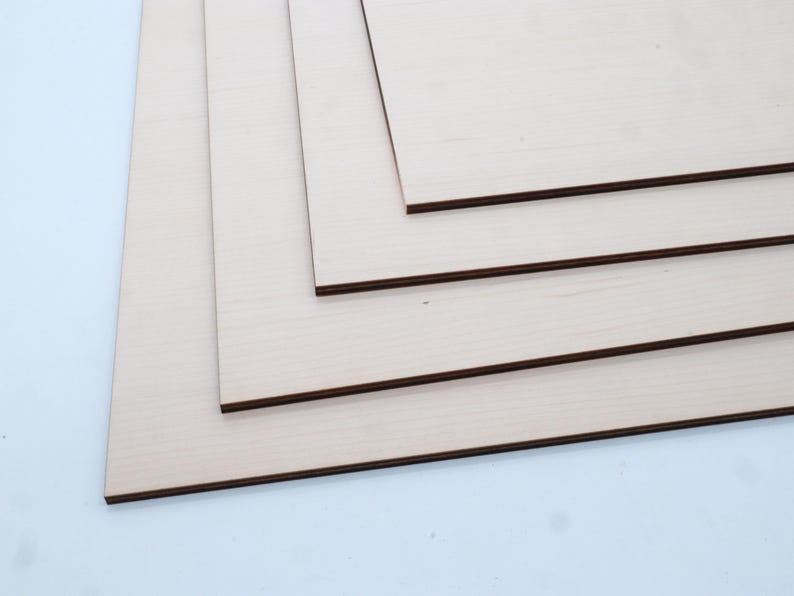 May include: Four pieces of unfinished wood veneer plywood, stacked on top of each other. The plywood is light brown in colour and has a smooth surface.