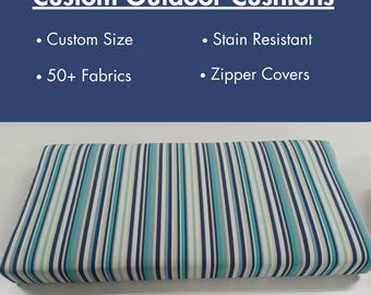May include: A striped outdoor cushion with blue, white, and beige stripes. The cushion is made with stain-resistant fabric and has a zipper cover. Custom Size and 50+ Fabrics.