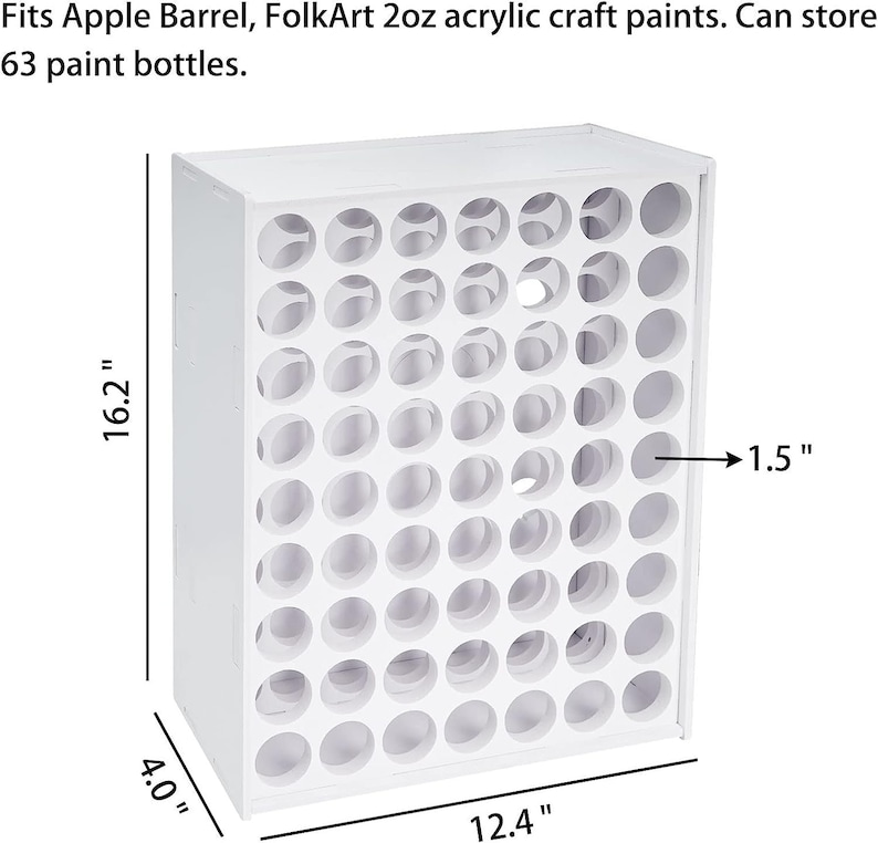 May include: White wooden paint bottle storage rack with 63 holes, measuring 16.2 inches tall, 12.4 inches wide, and 4 inches deep. Each hole is 1.5 inches in diameter.