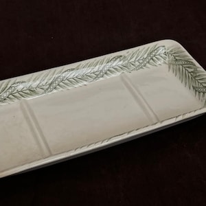 Può includere: Un portasapone in ceramica bianca con un motivo a felce verde. Il portasapone ha tre scomparti.