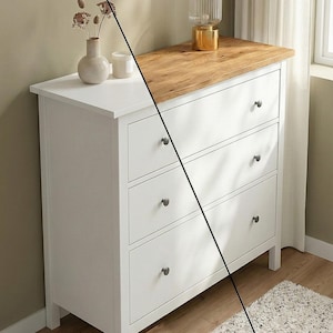 Könnte beinhalten: Eine weiße Kommode mit drei Schubladen und einer Oberseite aus Naturholz. Die Kommode hat dunkle Knöpfe und steht vor einer neutralen Wand. Ein goldgerahmter Spiegel und eine Lampe sind sichtbar. Der Text "Halt die Frist" ist sichtbar.