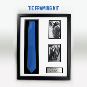 May include: A black picture frame with a blue tie, two black and white photographs, and a silver plaque that reads "Mr & Mrs Smith 17/08/24 Somerset House".