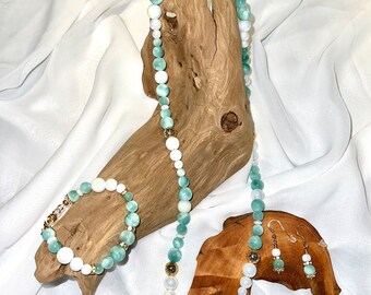 May include: A set of green and white gemstone jewelry, including a necklace, bracelet, and earrings. The necklace and bracelet feature alternating green and white beads, while the earrings are simple green and white drops.